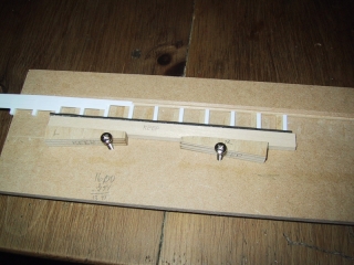 This simple jig hold the bridge tie extension in alignment so the decking can be glued in place.